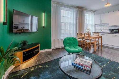 a living room with a table and a green wall at The Pottergate Residence - Norwich Lanes in Norwich