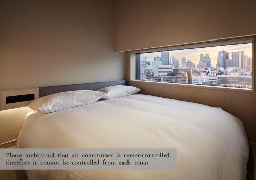a bedroom with a large bed with a large window at ONSEN RYOKAN YUEN SHINJUKU in Tokyo