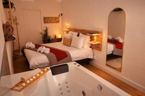 a bedroom with a large bed and a bath tub at Perle Dazur Jacuzzi Suite Parking Prive 5min Mer in Menton