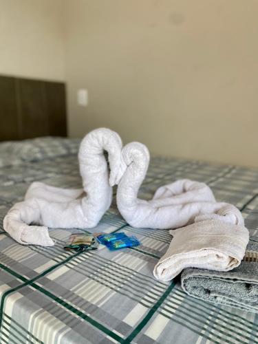 a bed with towels and a couple of swans at Chalés Sonho Meu in Munhoz