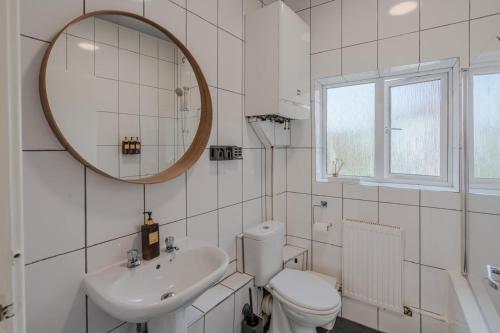 a bathroom with a sink and a toilet and a mirror at The Pottergate Residence - Norwich Lanes in Norwich