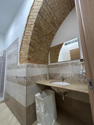 a bathroom with a sink and a brick wall at Kalgheros in Agrigento