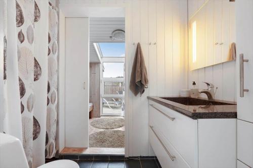 a kitchen with a sink and a door to a patio at 208-Ringkobing-Fladsbjergvej-226 in Klegod