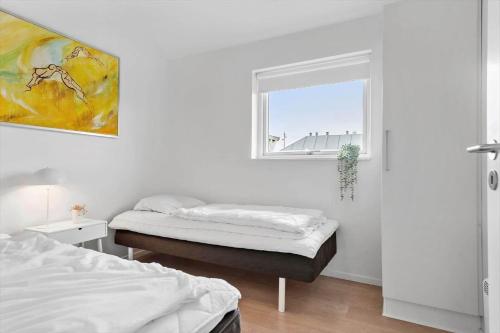 a bedroom with two beds and a window at 1130-Ringkobing-Sletten-18 in Søndervig