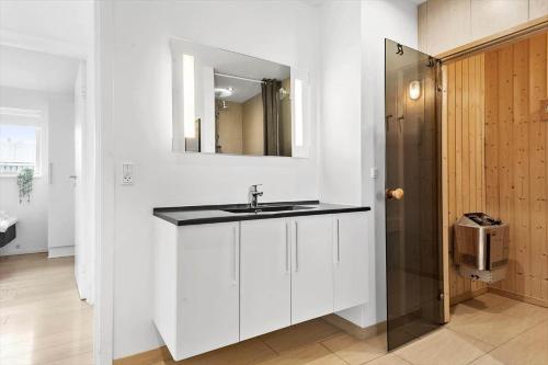a bathroom with a sink and a mirror at 1130-Ringkobing-Sletten-18 in Søndervig