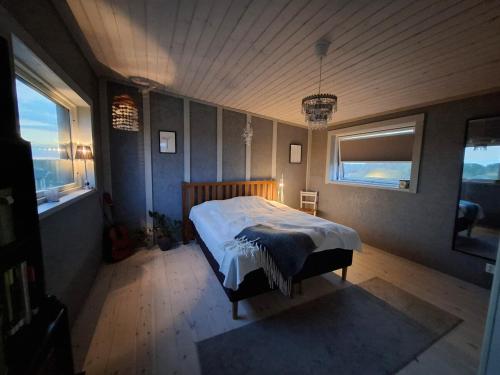 a bedroom with a bed in a room with two windows at Newly-built villa in a perfect location! in Grebbestad