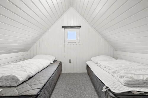 two beds in a white room with a window at 290-Ringkobing-Nordso-Ferievej-50 in Nørre Lyngvig