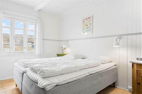 a white bedroom with a large bed and a window at 1154-Ringkobing-Nordsovej-50 in Søndervig