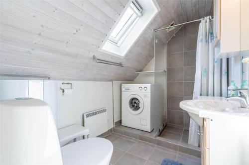 a bathroom with a washing machine and a sink at 221-Ringkobing-Havklitvej-72 in Klegod