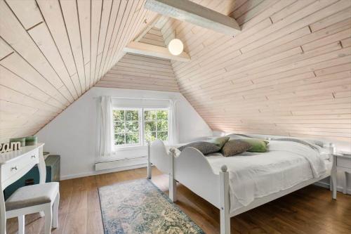 a bedroom with a white bed in a attic at 123-Ringkobing-Granalle-3 in Nørby
