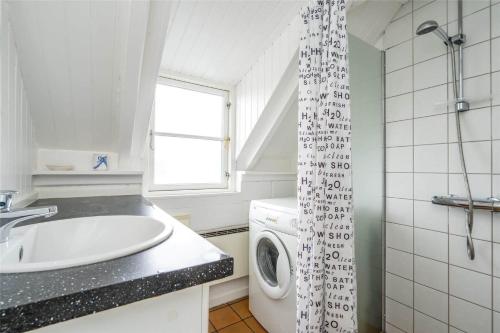 a bathroom with a sink and a washing machine at 207-Ringkobing-Nordso-Ferievej-27 in Nørre Lyngvig