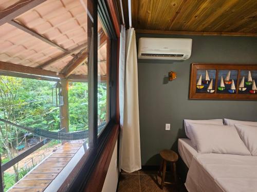a small bedroom with a bed and a window at Green Area House in Abraão