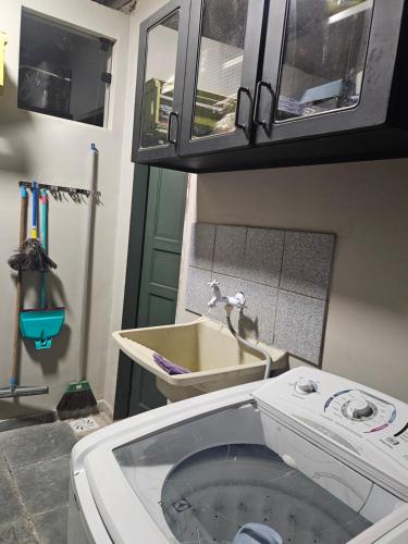 a bathroom with a sink and a faucet at Green Area House in Abraão