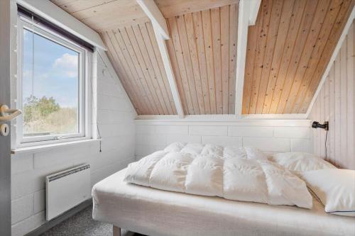 a white bed in a room with a window at 2254-Ringkobing-Nordso-Ferievej-52 in Nørre Lyngvig