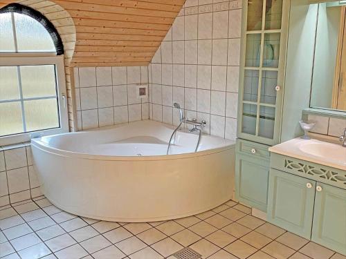 a bathroom with a large tub and a sink at 152-Ringkobing-Regnspovedalen-6 in Nørby