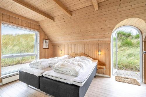 a large bed in a room with a large window at 152-Ringkobing-Regnspovedalen-6 in Nørby
