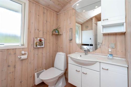 a bathroom with a toilet and a sink and a mirror at 078-Ringkobing-Rorsangervej-11 in Nørby