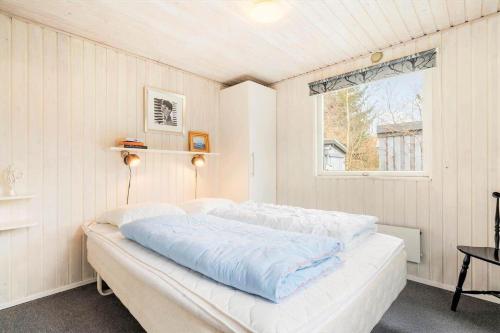 a bed in a room with a window at 095-Ringkobing-Risbjergvej-12 in Nørby