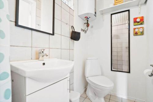 a white bathroom with a sink and a toilet at 235-Ringkobing-Vestklitvej-11 in Klegod