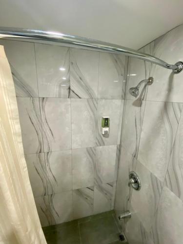 a shower with a glass door in a bathroom at Kings Inn Orillia in Orillia