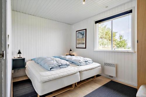 a bedroom with a large bed and a window at 265-Ringkobing-Klitsvinget-5 in Klegod