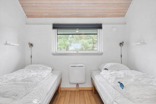 two twin beds in a room with a window at 1103-Ringkobing-Frans-Julius-Vej-17 in Klegod