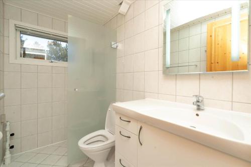 a bathroom with a sink and a toilet and a mirror at 233-Ringkobing-Milevej-38 in Klegod