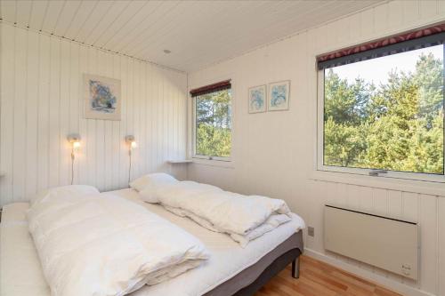 a bedroom with two beds and a window at 233-Ringkobing-Milevej-38 in Klegod