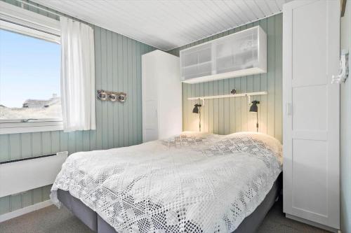a bedroom with a white bed and a window at 278-Ringkobing-Fladsbjergvej-54 in Klegod