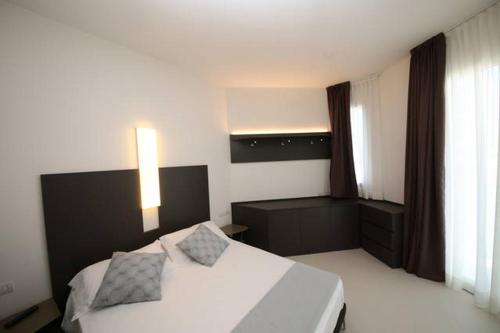 a bedroom with a white bed with two pillows on it at Residence Cristallo Senigallia in Senigallia