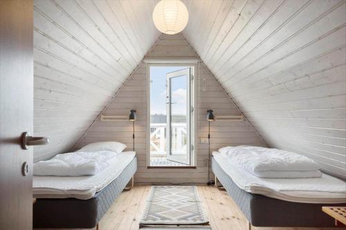 two beds in a room with a window at 260-Ringkobing-Vestklitvej-13 in Klegod