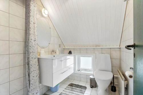 a bathroom with a toilet and a sink and a mirror at 273-Ringkobing-Nordso-Ferievej-28 in Nørre Lyngvig