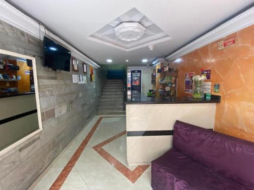 eine Lobby mit Bar und einem lila Sofa in der Unterkunft Hotel Nova Real in Ibagué