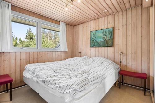 a bedroom with a large bed and two windows at 1082-Ringkobing-Milevej-11 in Klegod