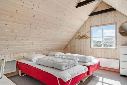 a bedroom with a large bed in a wooden wall at 179-Ringkobing-Nordsovej-236 in Søndervig