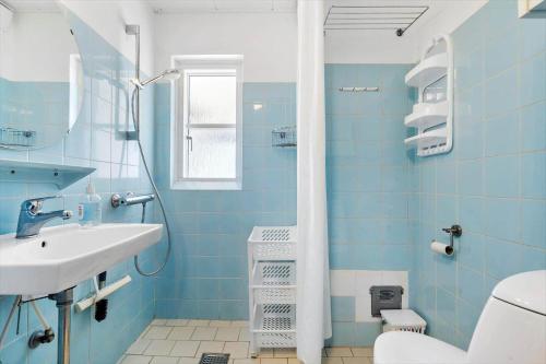 a blue bathroom with a sink and a shower at 179-Ringkobing-Nordsovej-236 in Søndervig