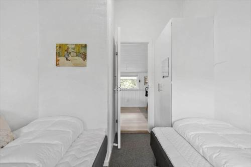 a room with two white beds and a hallway at 232-Ringkobing-Jakob-Bondes-Vej-35 in Klegod