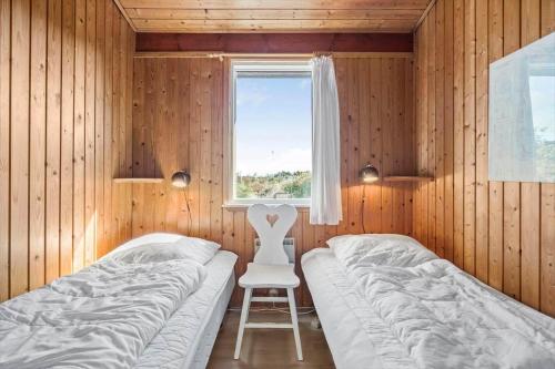 a bedroom with two beds and a chair in it at 201-Ringkobing-Fladsbjergvej-234 in Klegod