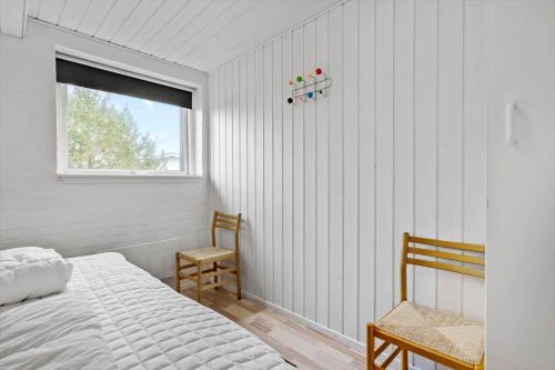 a bedroom with a bed and a window and a chair at 292-Ringkobing-Vestklitvej-12 in Klegod