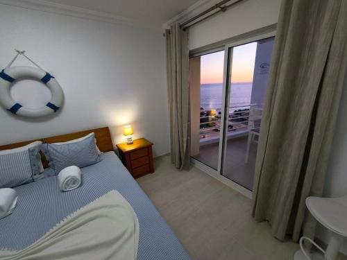 a bedroom with a bed and a large window at Seaview Varandas do Sol 2 in Portimão