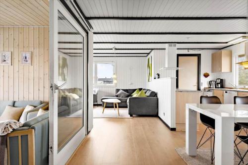 a living room and kitchen with a couch and a table at 280-Ringkobing-Klitsvinget-11 in Klegod