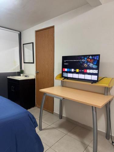 a room with a desk with a television on top of it at Casa providencia suites in Guadalajara