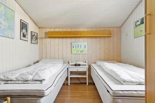 two beds in a small room with a desk at 268-Ringkobing-Lyngvejen-63 in Klegod