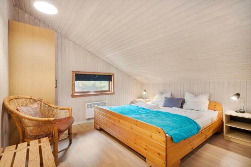 a bedroom with a large bed and a chair at 2253-Ringkobing-Fladsbjergvej-234-E in Klegod