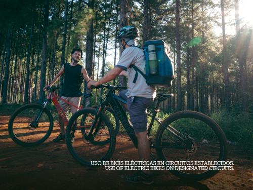 two men standing with their bikes on a trail at Reserva Natural Iguazú - Pristine Luxury Camp in Puerto Libertad