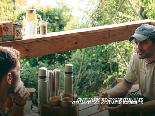a man sitting at a table with another man at Reserva Natural Iguazú - Pristine Luxury Camp in Puerto Libertad