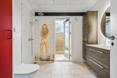 a bathroom with a painting of a woman on the wall at 1149-Ringkobing-Holmsborgvej-32 in Søndervig