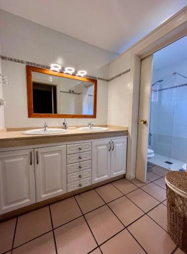 a bathroom with a sink and a mirror and a shower at Doral Paradise Gran Canaria in Maspalomas
