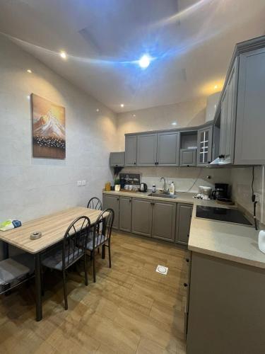 a kitchen with a wooden table and a table and chairs at قنوف-شقة فندقية خاصة ذ in Abha