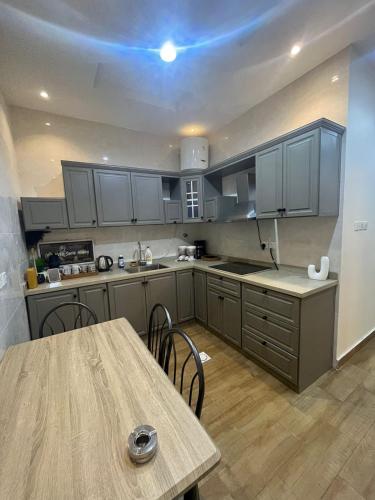 a kitchen with gray cabinets and a wooden table at قنوف-شقة فندقية خاصة ذ in Abha
